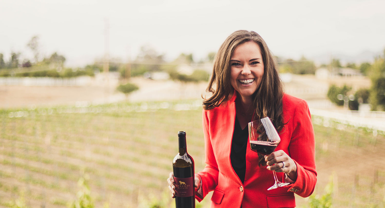 Kellie Martin holding a bottle of fine and a glass of wine.