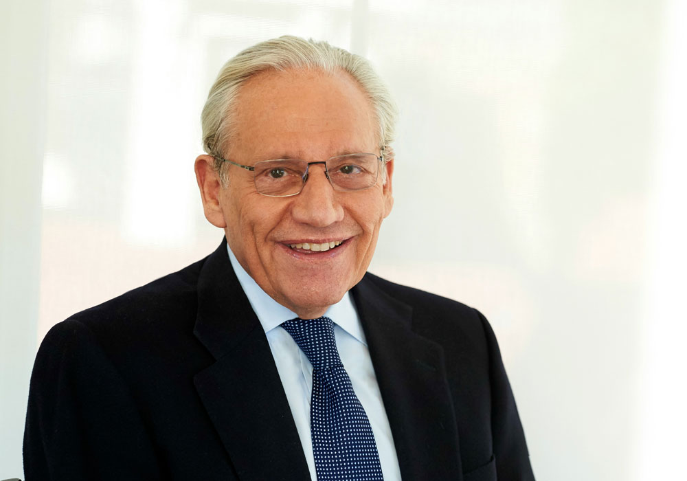 Man in suit and blue tie against a white background