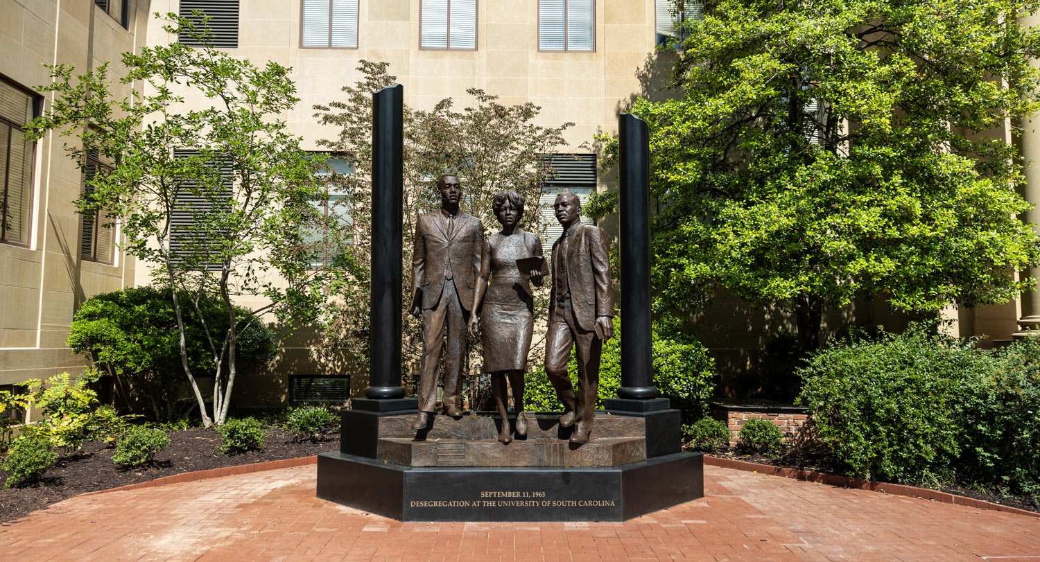 A 12-foot bronze statue of three people stands in front of McKissick Museum.