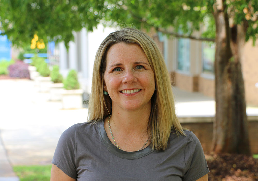 A woman standing in an outdoor area.