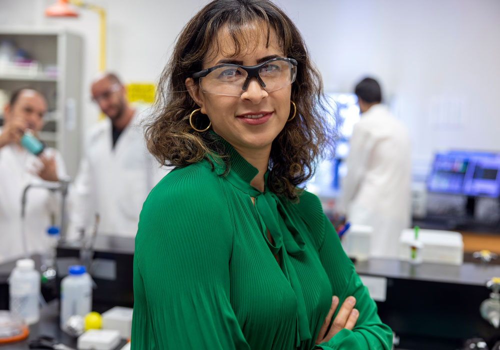woman wearing safety goggles stands in a lab