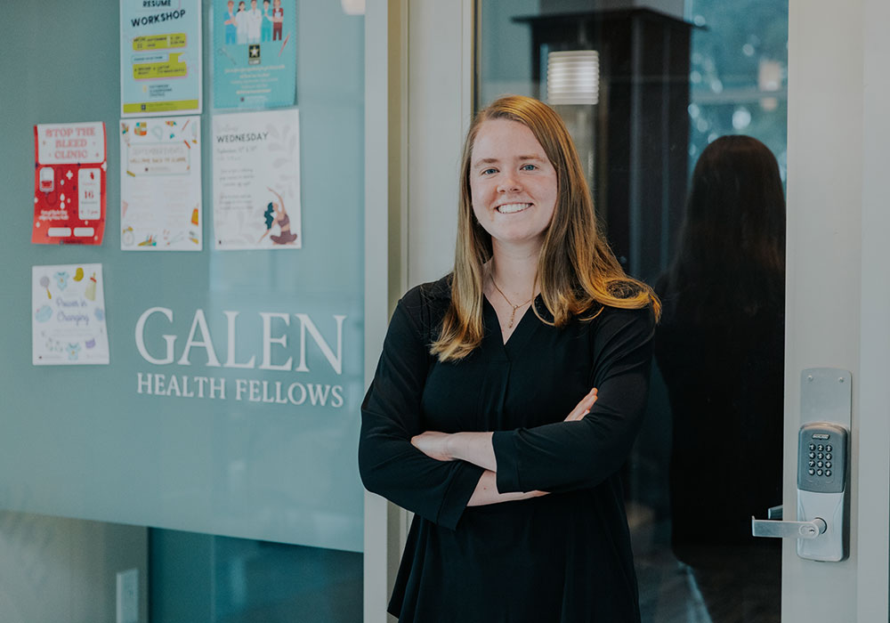 Woman standing with her arms crossed over her chest in front of glass door