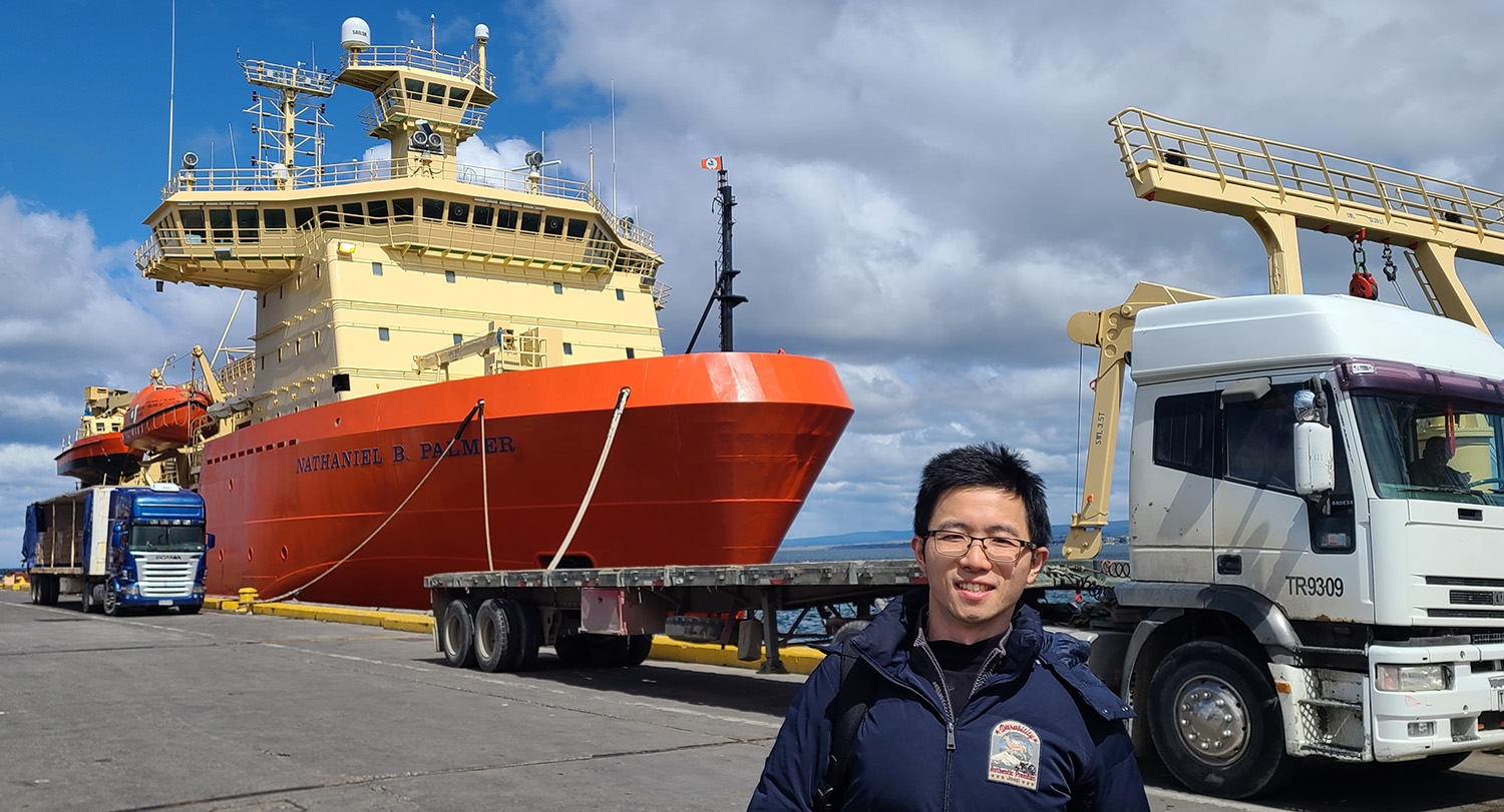 Asian man standing on dock in foreground with ship visible behind him