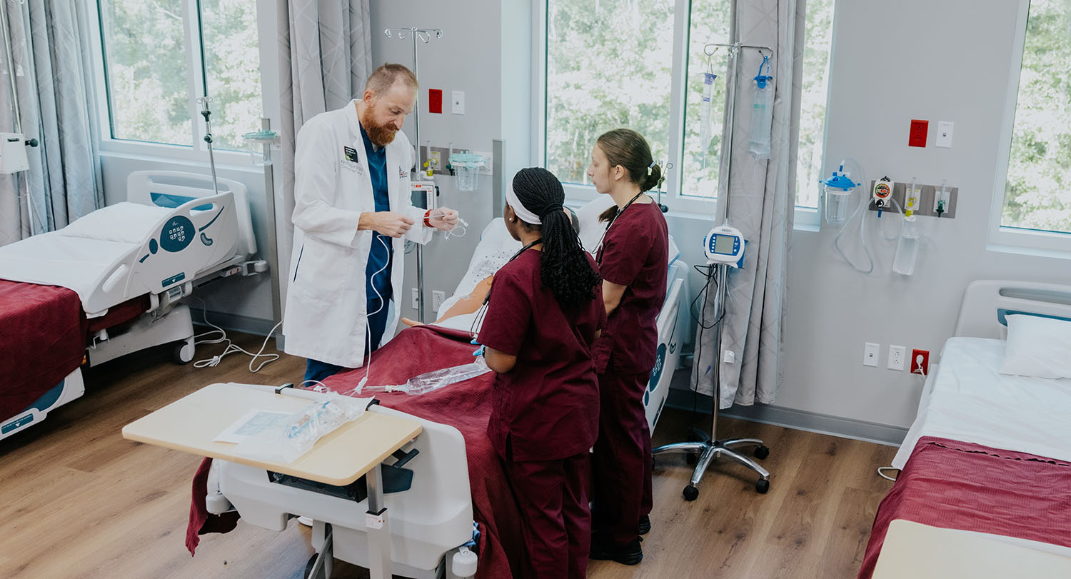 A doctor discusses a case in hospital setting with two nursing students