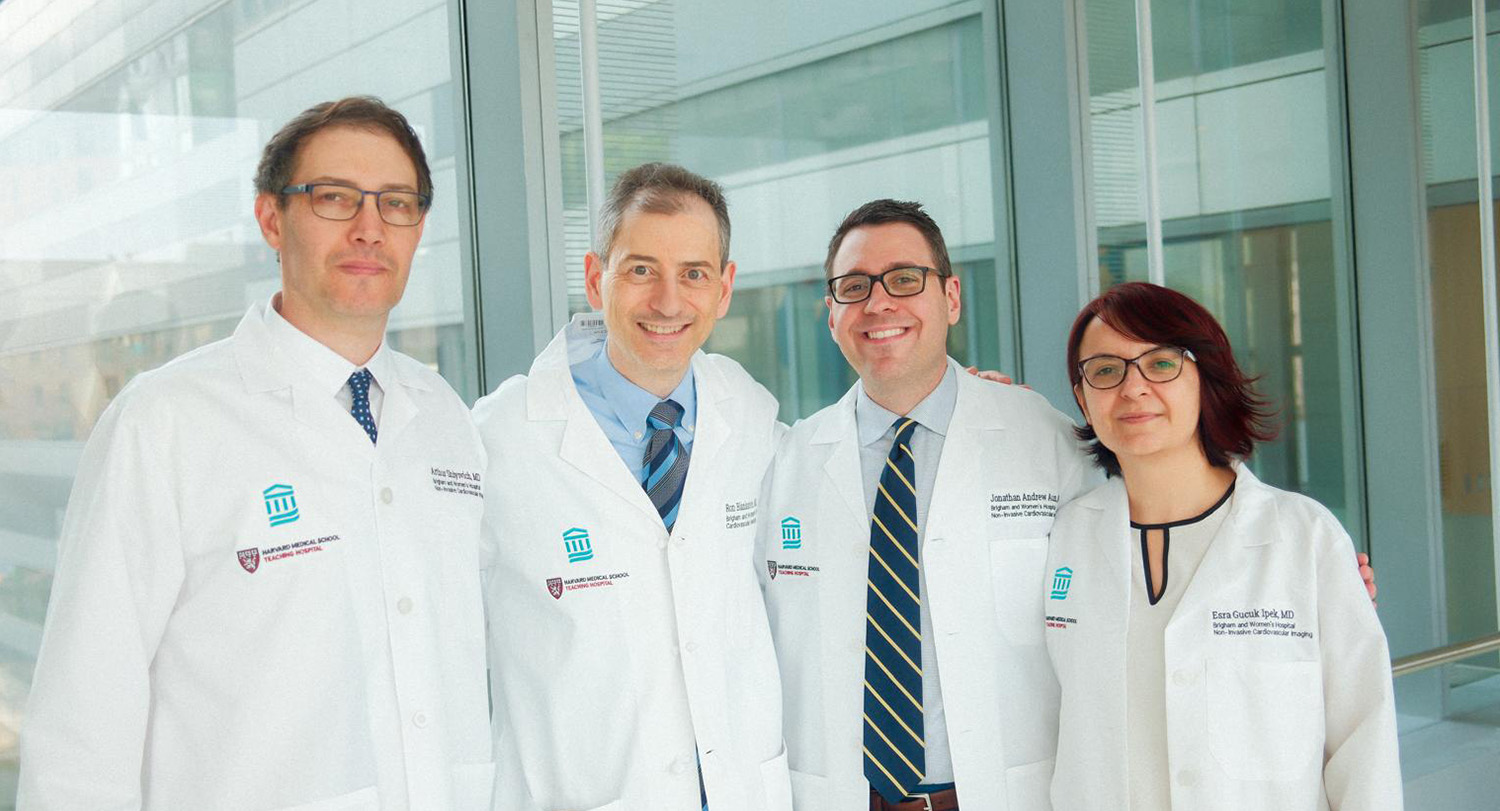 Three doctors standing in the glass hallway of a clinic