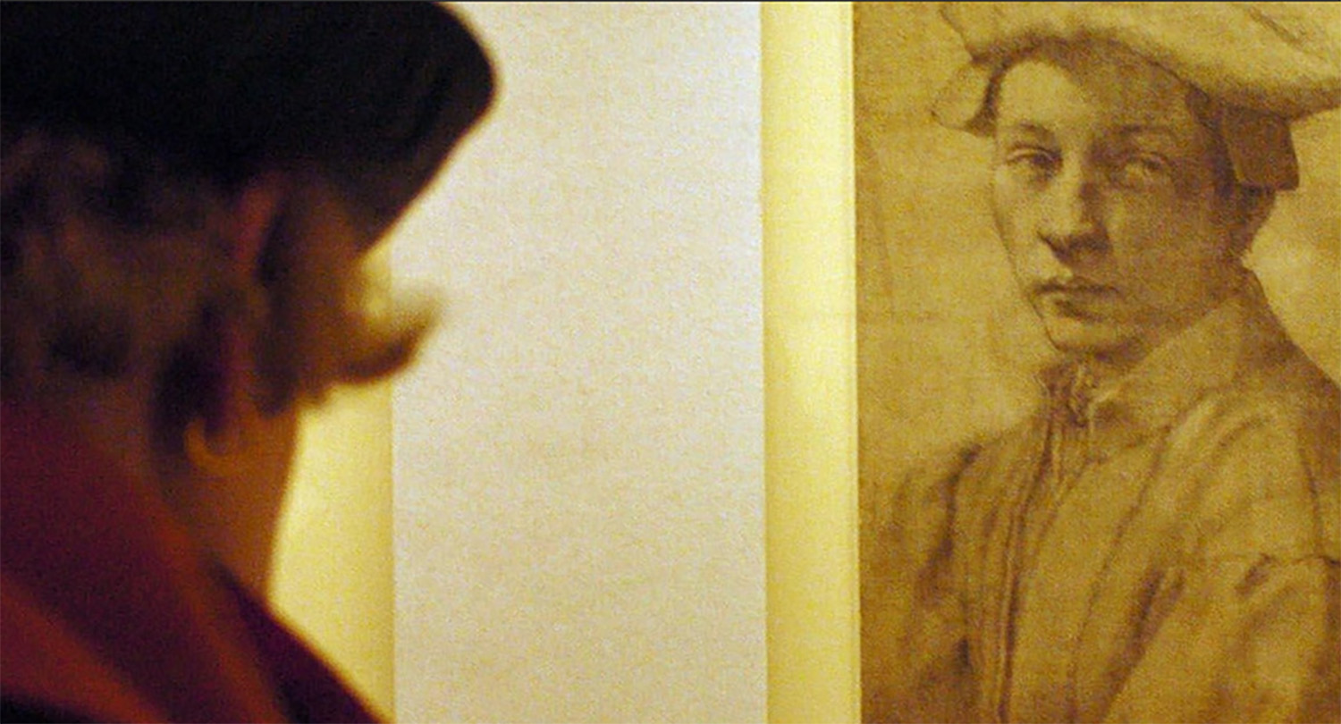 A sepia-toned photo of someone (pictured from behind) admiring a bust drawing by Michelangelo