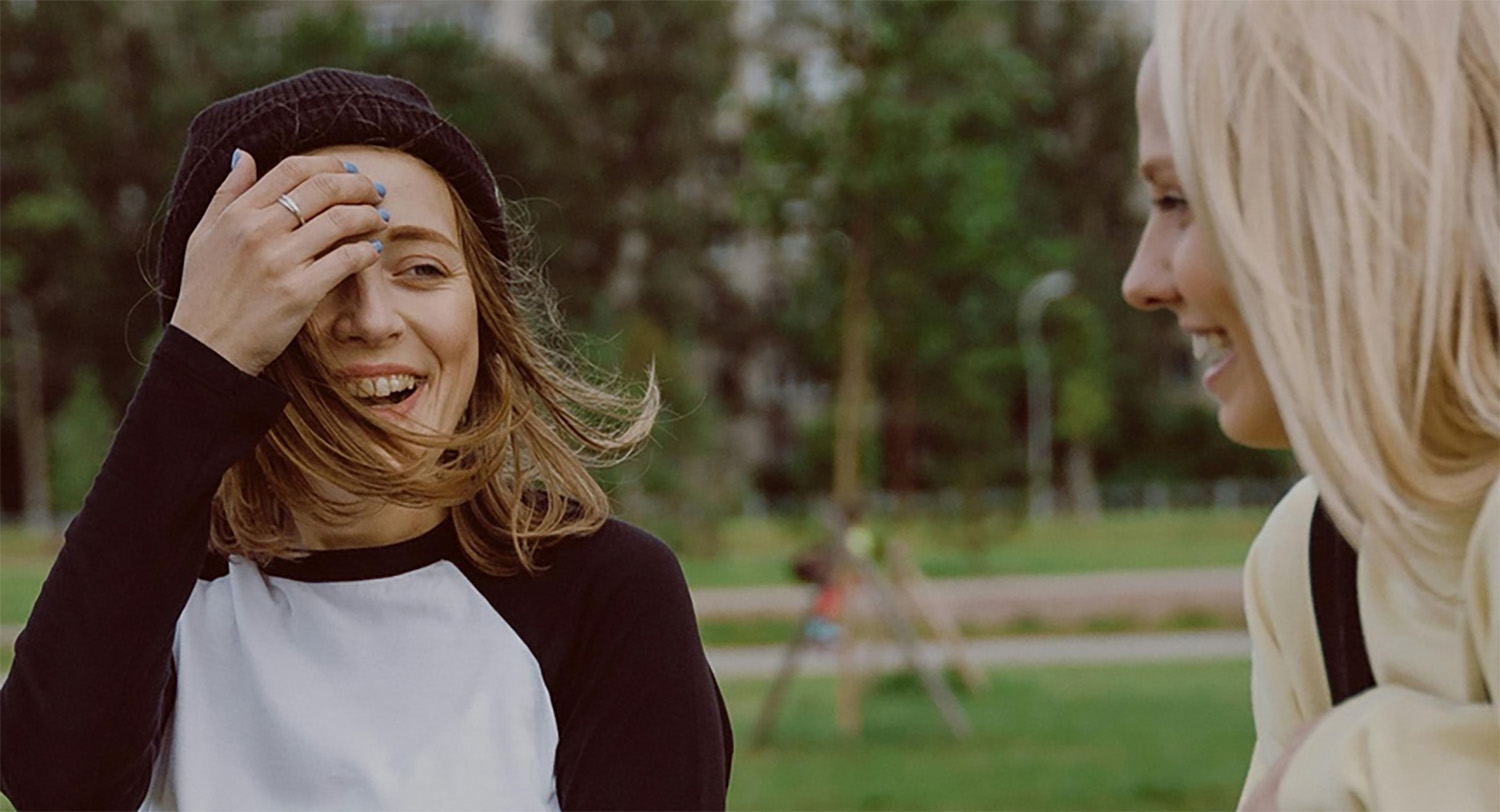 Two young girls outside laughing at a joke