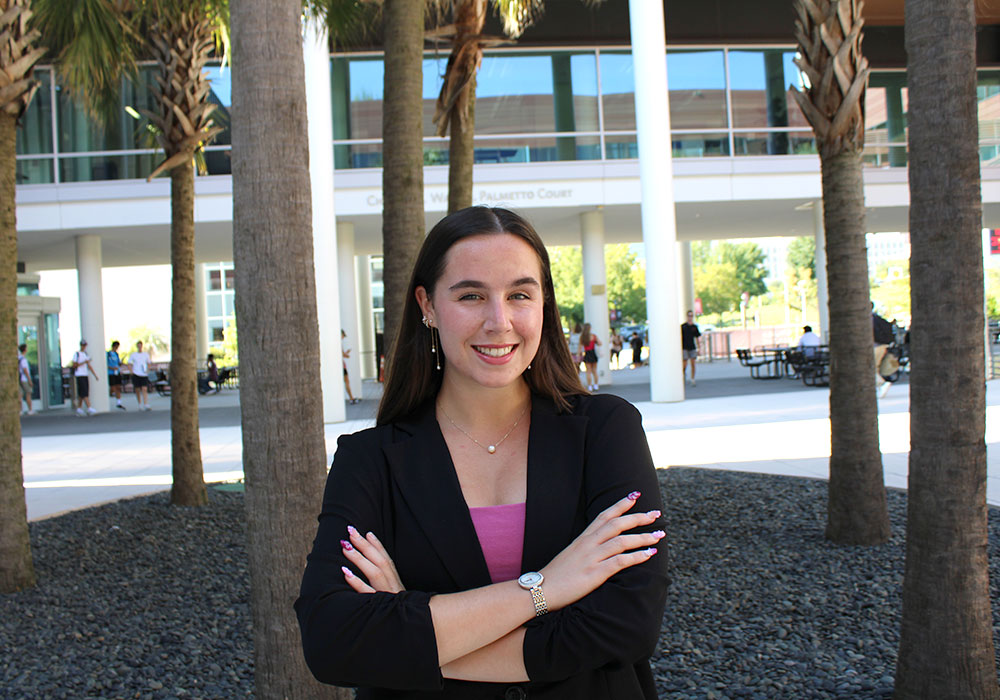 Breanna Price crosses her arms in front of the business school