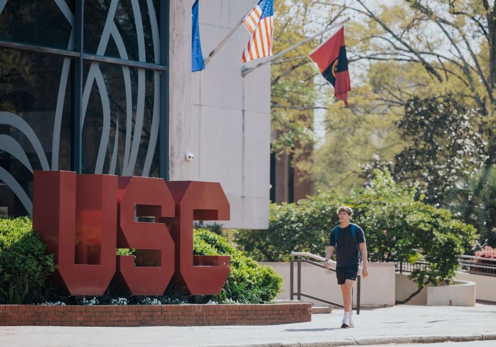 Student walking in front of USC at Russell House student union