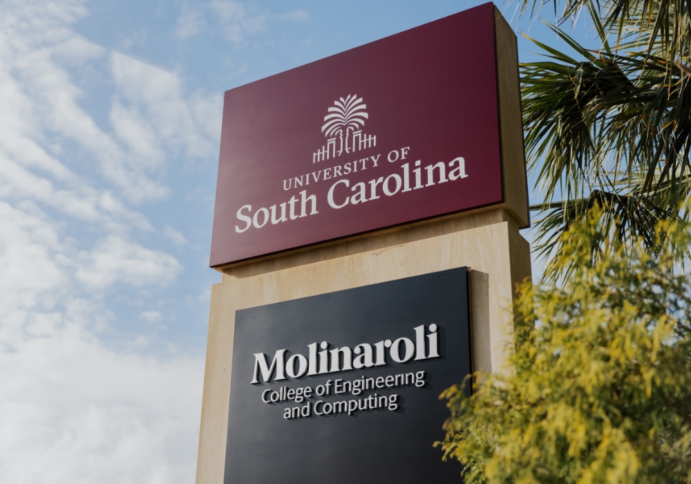 Signage of the Molinaroli College of Engineering and Computing under a garnet University of South Carolina sign