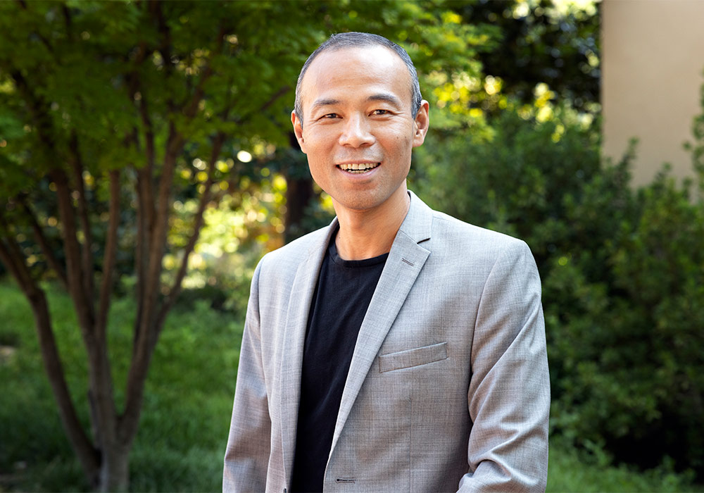 Qian Wang stands outdoors on USC campus