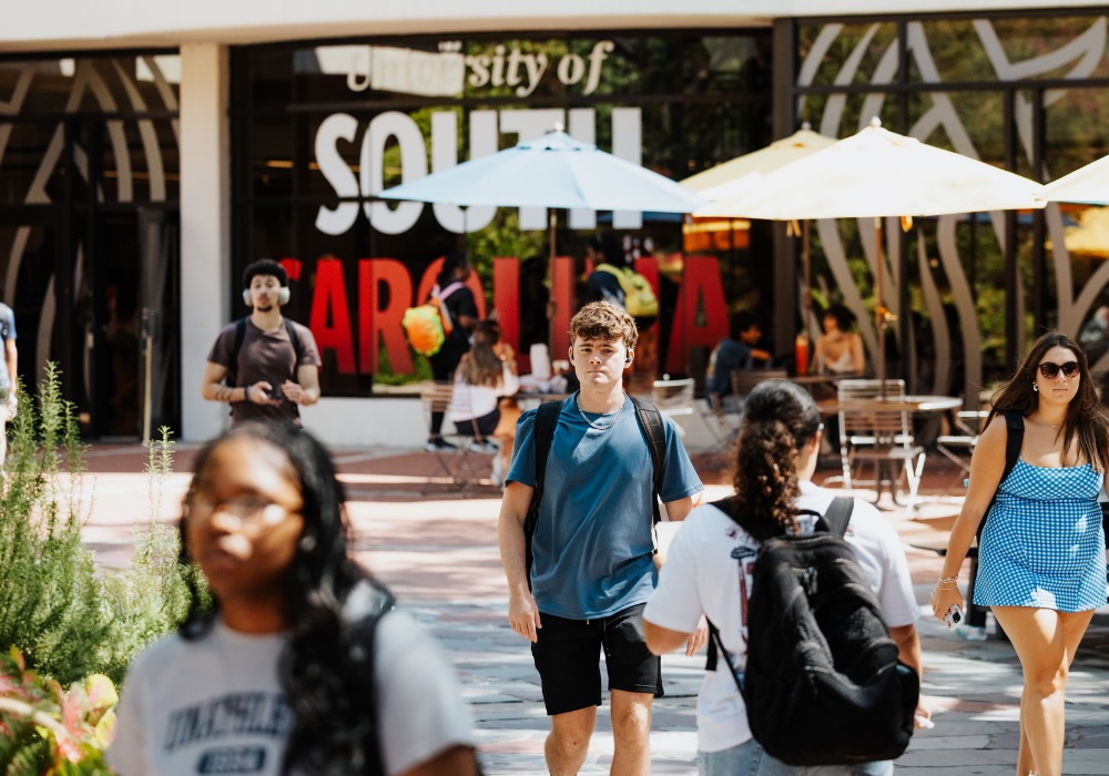 students walking in front of a university of south carolina sign
