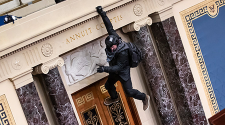 Officer hanging from the wall during the Jan. 6 riot at the U.S. capitol.