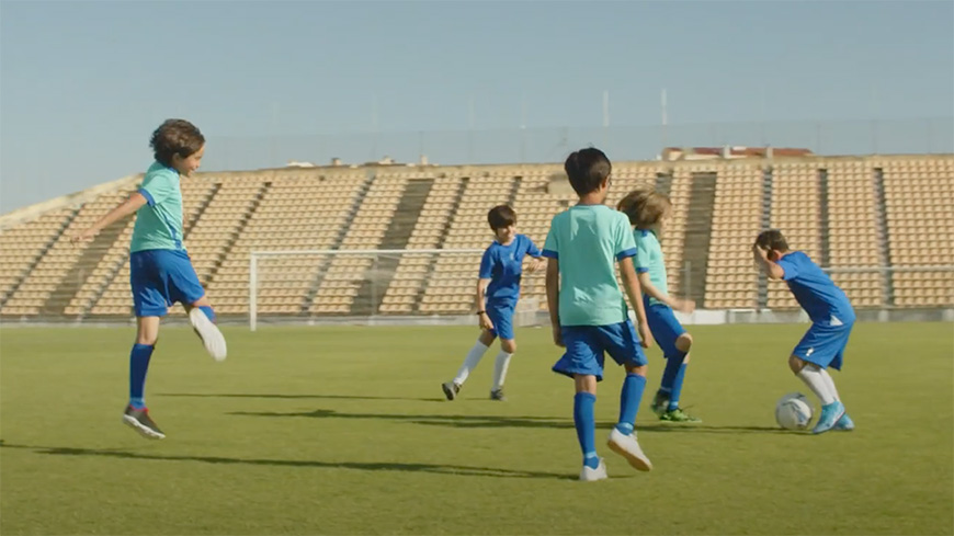 A group of kids playing soccer in a stadium.