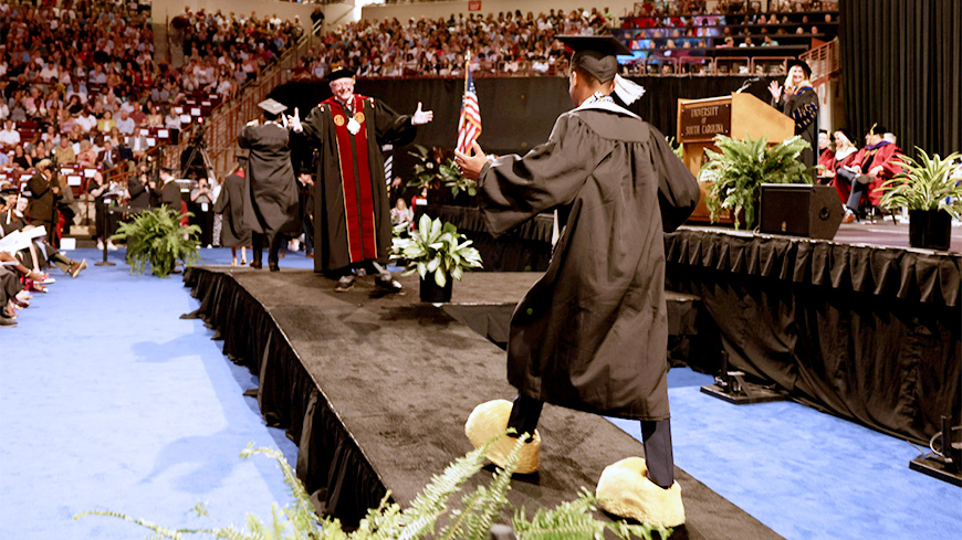 Tramon Miles walking across the stage.