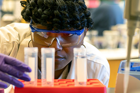 girl observing test tubes in a research lab