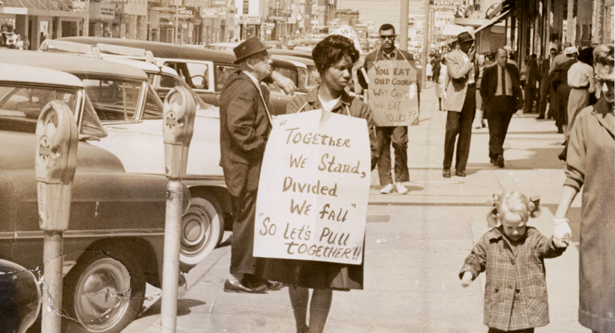 Two people with signs around their necks protesting segregation