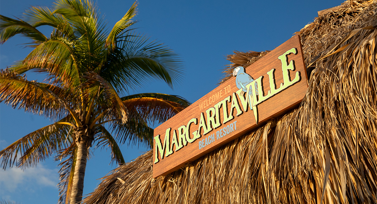 Margaritaville sign surrounded by blue skies and palm trees