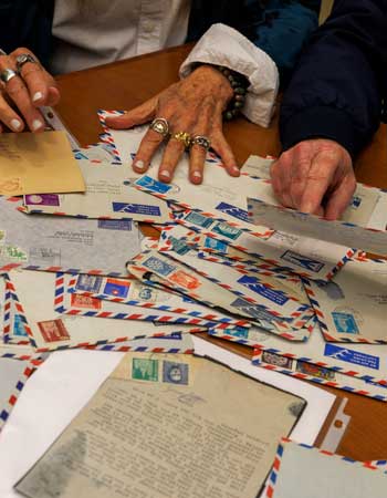 Old letters in envelopes spread out on a table. 