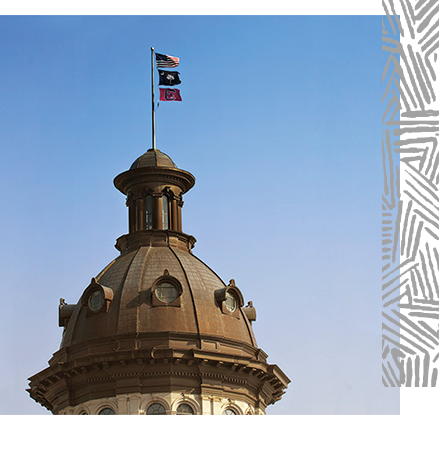 The dome of the South Carolina Statehouse with flags flying.