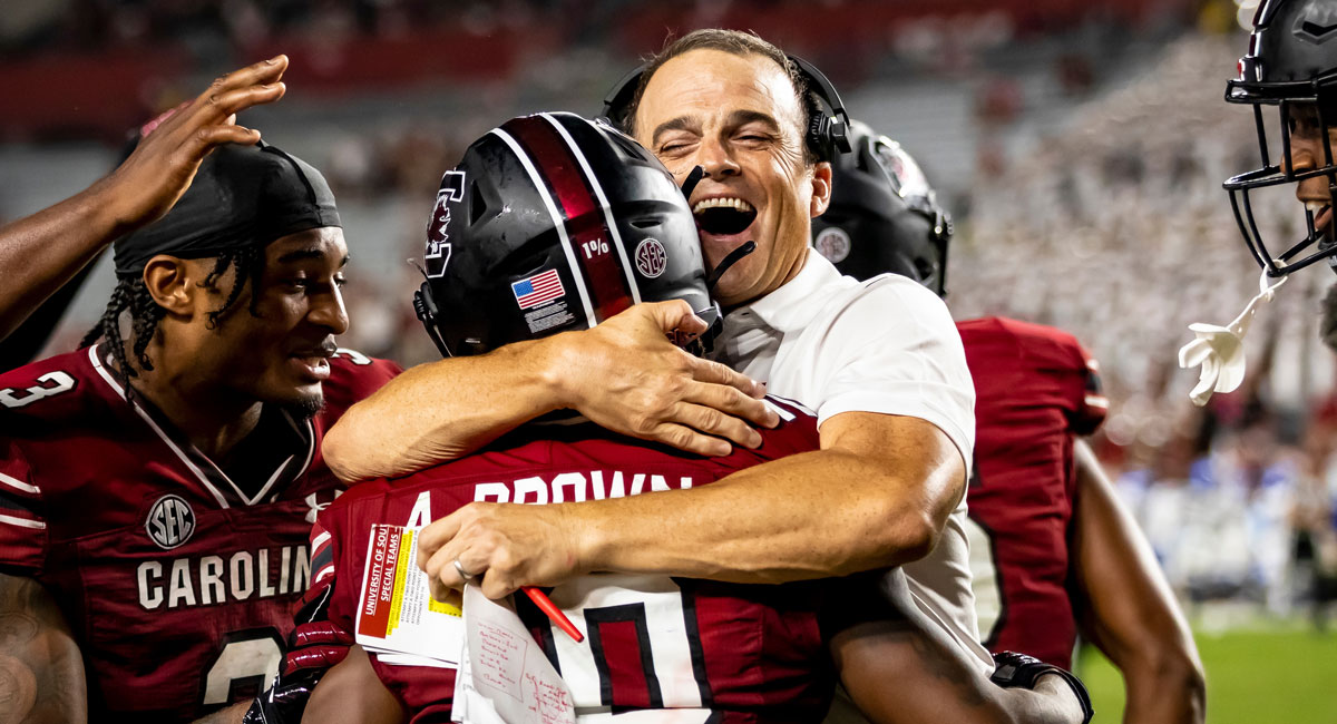 Shane Beamer celebrates with football players.