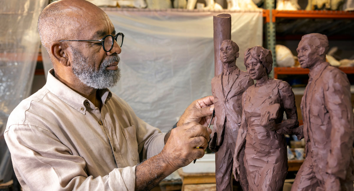 Basil Watson works on the desegration sculpture.