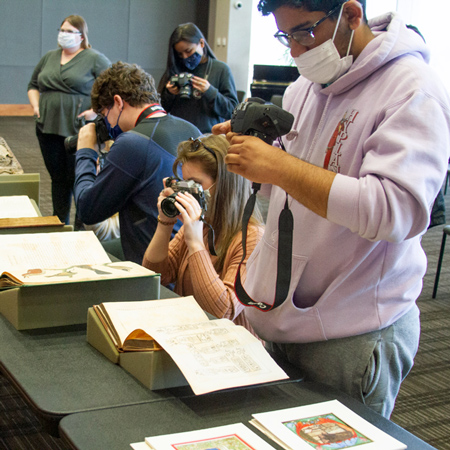 Students is Jess Peri's photography class take photos of books in University Libraries