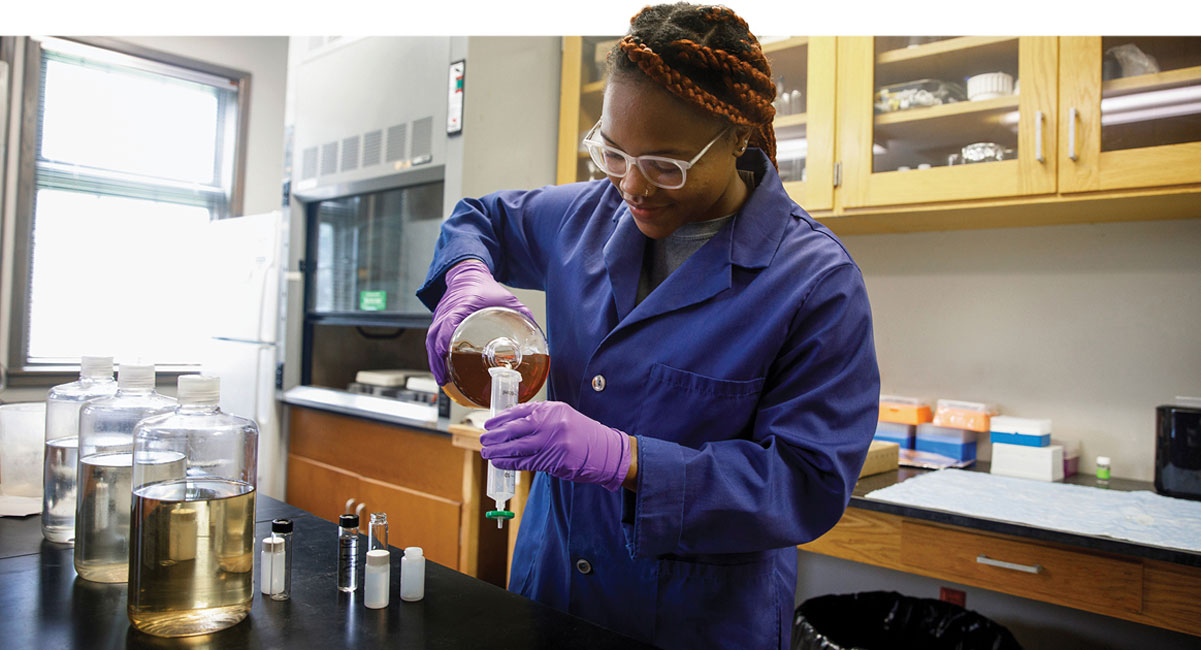 Gwen Hopper pours liquid into beaker