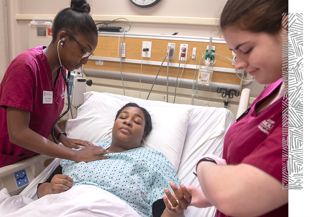 Two nursing students working with a patient.