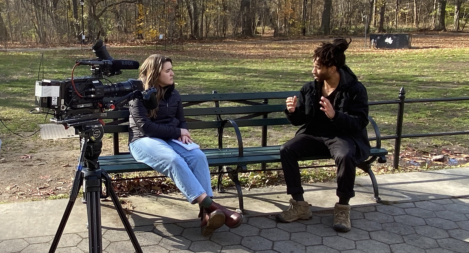 two people talking on a park bench