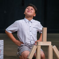 Boy performs on stage during theater camp.