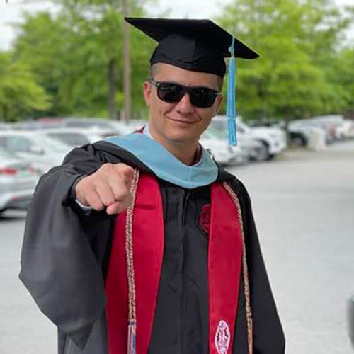 Ryan Buell posing with his graduation cap and gown