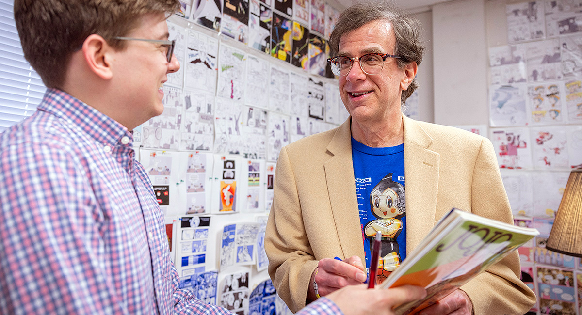 Northrop Davis and student look at book in professor's office