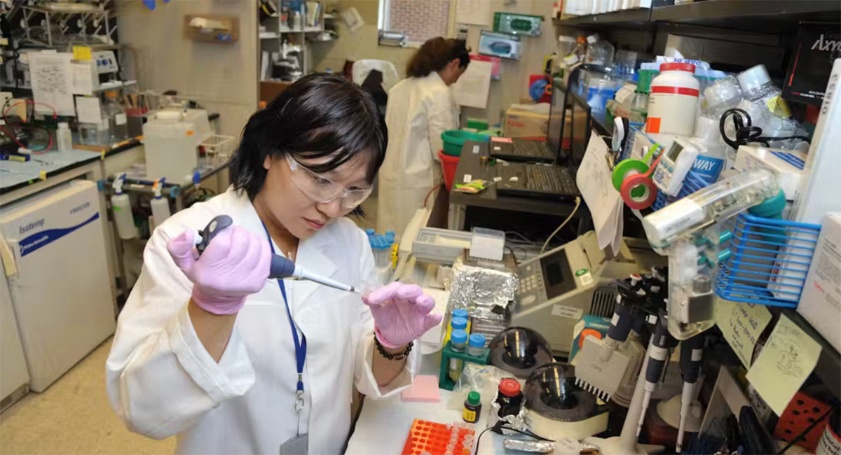 A woman in a lab coat doing an experiment in a medical lab.