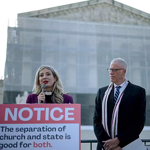 Woman with microphone speaks to crown outside U.S. Supreme Court.