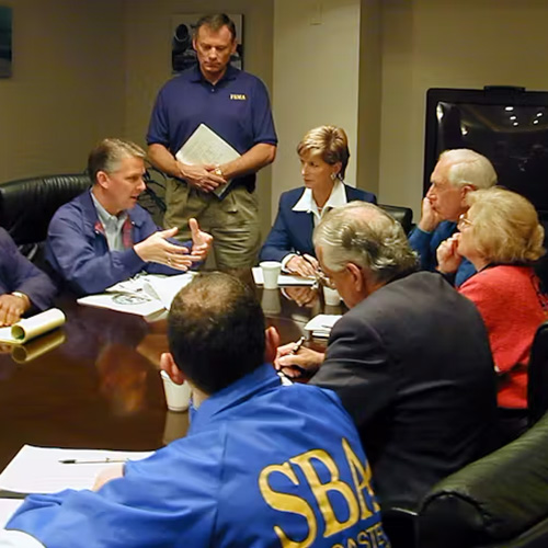 FEMA leaders gather around a meeting table.