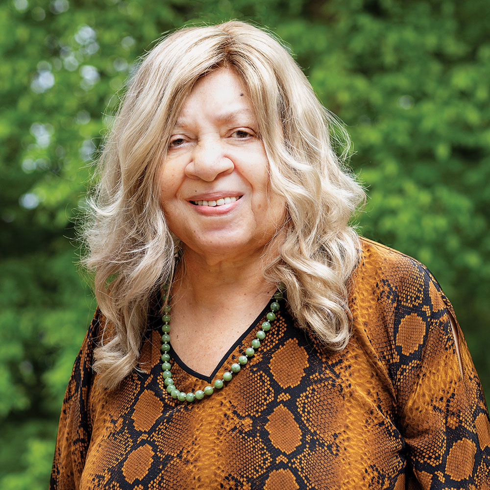 Henrie Monteith Treadwell smiles for the camera with greenery in the background.