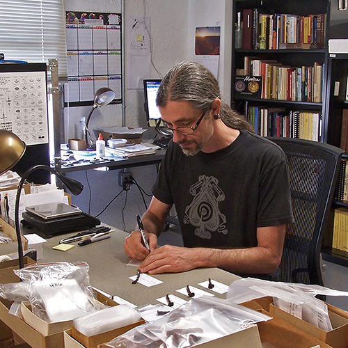 A resesarcher catalogues exccavated artifacts 