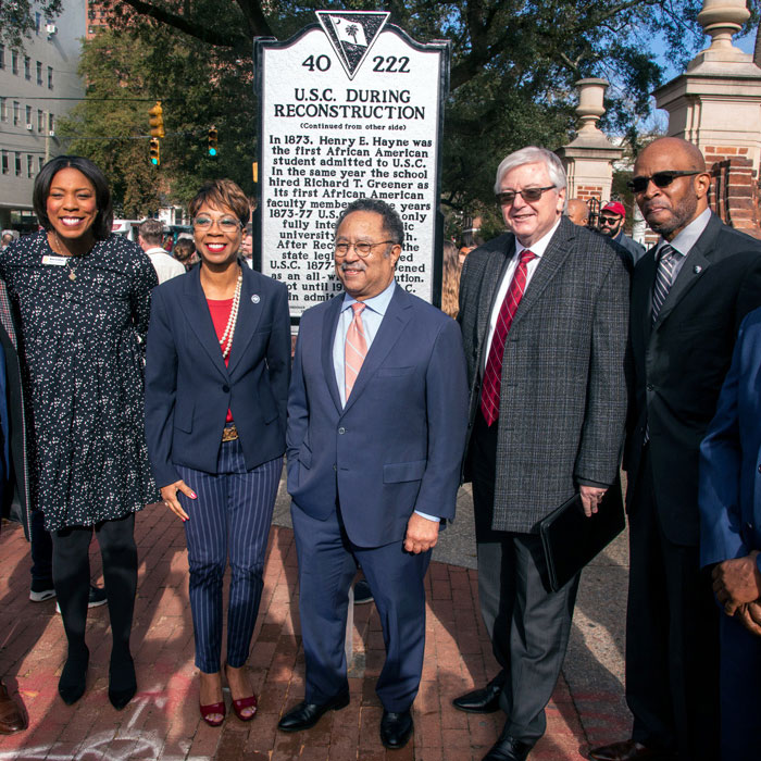 five people stand next to historical marking detailing USC During Reconstruction