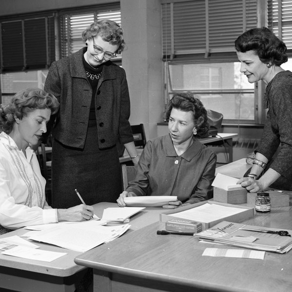 Ada B. Thomas talks with students at a table.