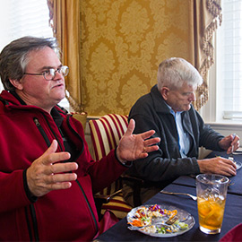 men eating at a table talking