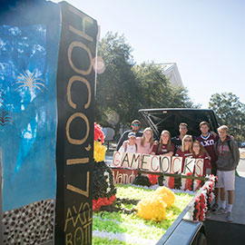 students stand near a homecoming float