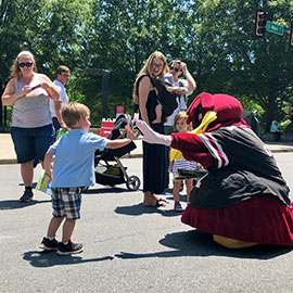 Cocky gives young child a high five on Main Street in Greenville