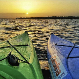 Two kayaks on a lake at sunset