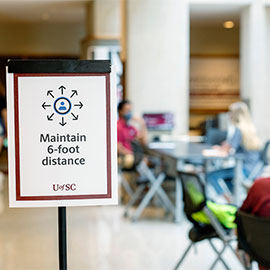 Maintain 6-foot distance sign in front of tables in the Russell House