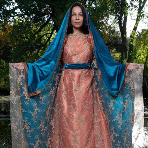 Film character Lady of Guadalupe in pink and lace dress and blue shawl over her head