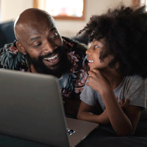 Father watching movie on a laptop with his daughter