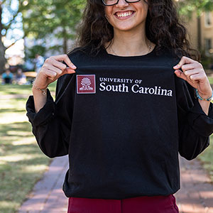 Person showing off a shirt with the new University of South Carolina logo.