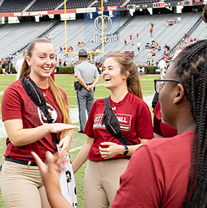 Student interns standing on the football field at the Spring Game.