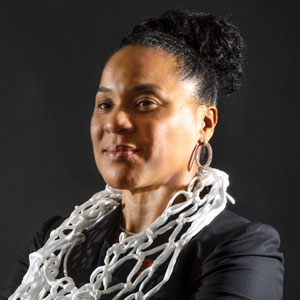 head and shoulders photo of coach dawn staley wearing a basketball net like a necklace